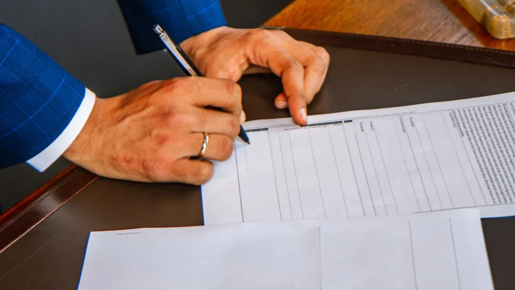 Dirigeant signant les documents juridiques d’une cession d’entreprise