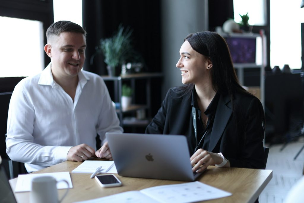 Un commercial et une cliente en rendez-vous autour d'un ordinateur portable